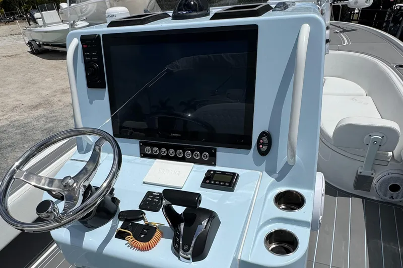 Slide: The Image of 2024 Contender 26 Bay boat console with steering wheel and navigation controls. - 24