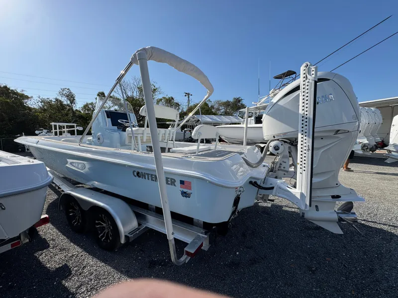 Slide: The Image of 2024 Contender 26 Bay boat on trailer, featuring powerful outboard motor. - 6