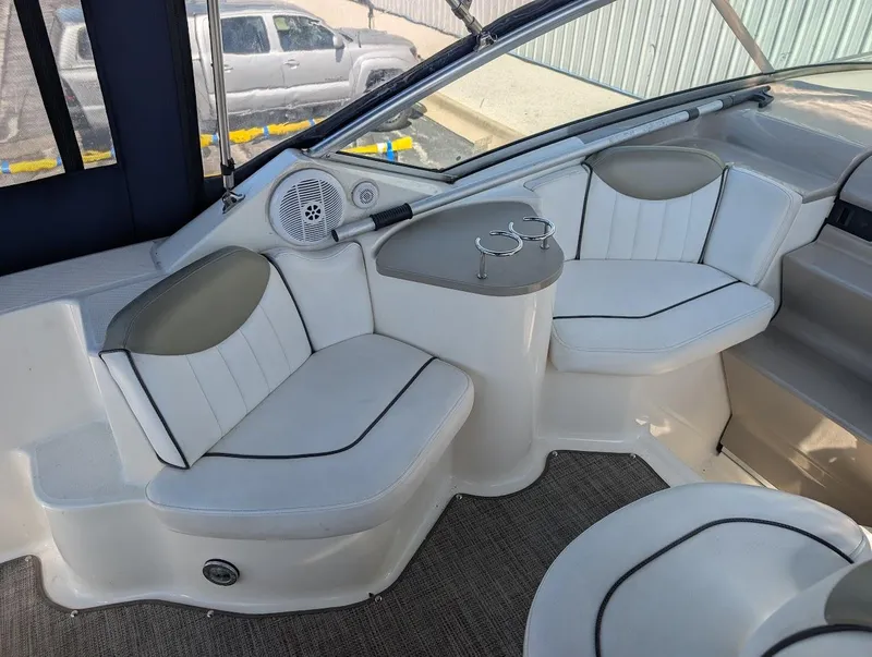 Slide: The Image of 2006 Sea Ray 240 Sundancer boat interior with white seating and cup holders. - 10