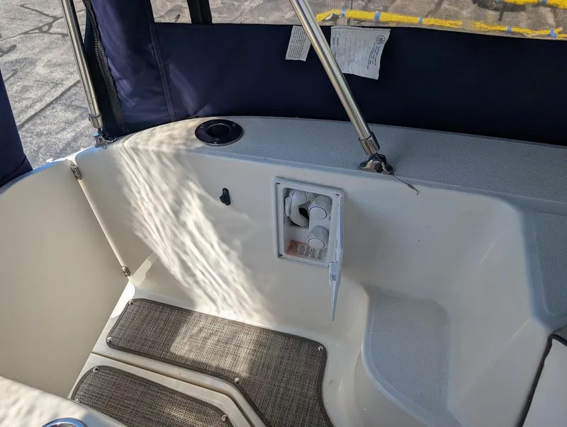 Slide: The Image of 2006 Sea Ray 240 Sundancer boat interior with seating and storage area. - 13