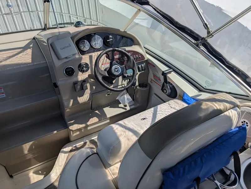Slide: The Image of 2006 Sea Ray 240 Sundancer boat cockpit with steering wheel and control panel. - 14