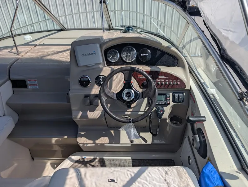 Slide: The Image of 2006 Sea Ray 240 Sundancer boat dashboard with steering wheel and navigation instruments. - 15