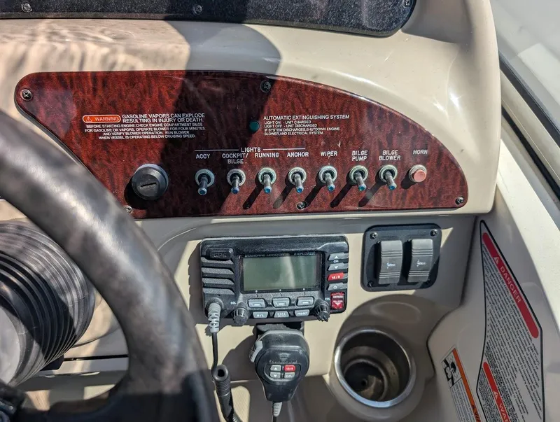 Slide: The Image of Control panel of a 2006 Sea Ray 240 Sundancer boat with switches and radio. - 18