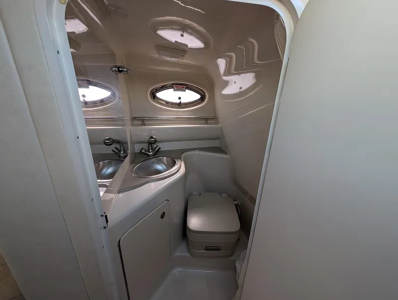 Slide: The Image of Compact bathroom in 2006 Sea Ray 240 Sundancer boat with sink and toilet. - 22