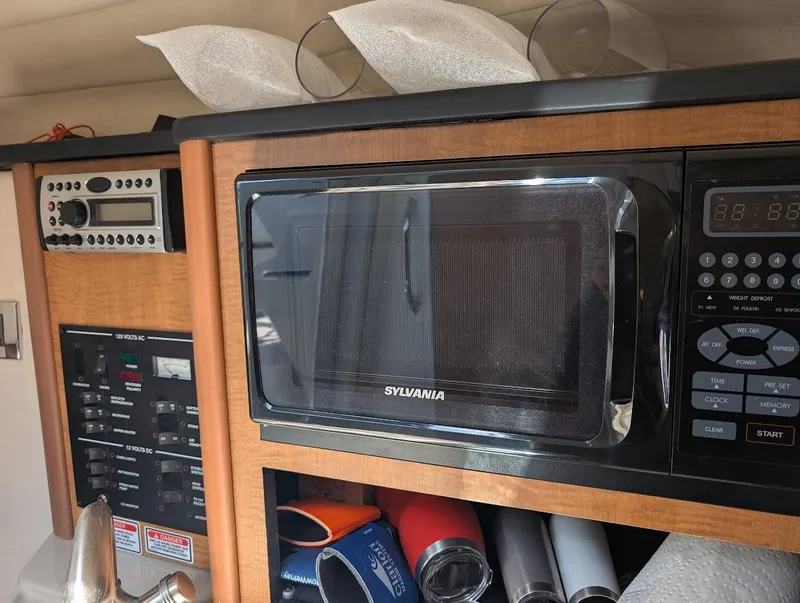 Slide: The Image of Interior of 2006 Sea Ray 240 Sundancer with Sylvania microwave and control panel. - 24
