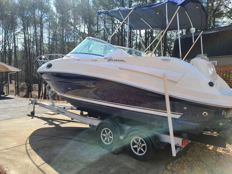 Slide: The Image of 2006 Sea Ray 240 Sundancer boat on trailer with blue canopy, parked outdoors. - 4