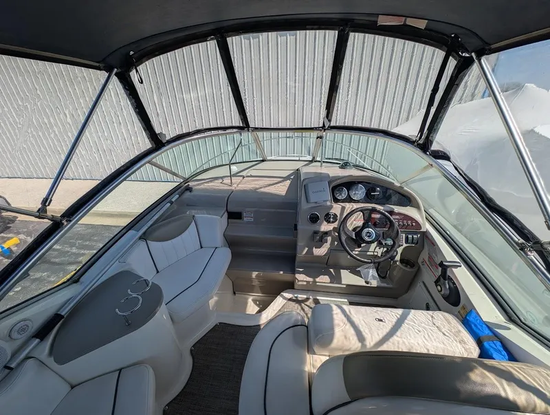 Slide: The Image of 2006 Sea Ray 240 Sundancer boat interior with steering wheel and seating area. - 9