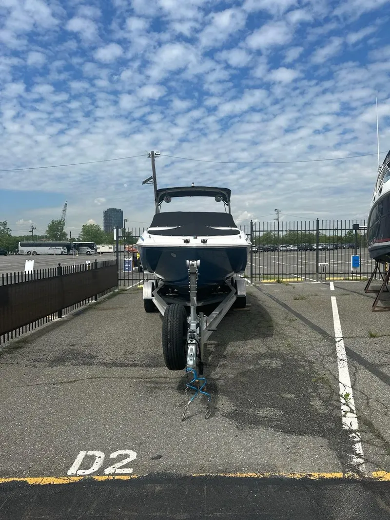 Slide: The Image of 2014 Regal 2700 Bowrider boat on trailer in parking lot under cloudy sky. - 13