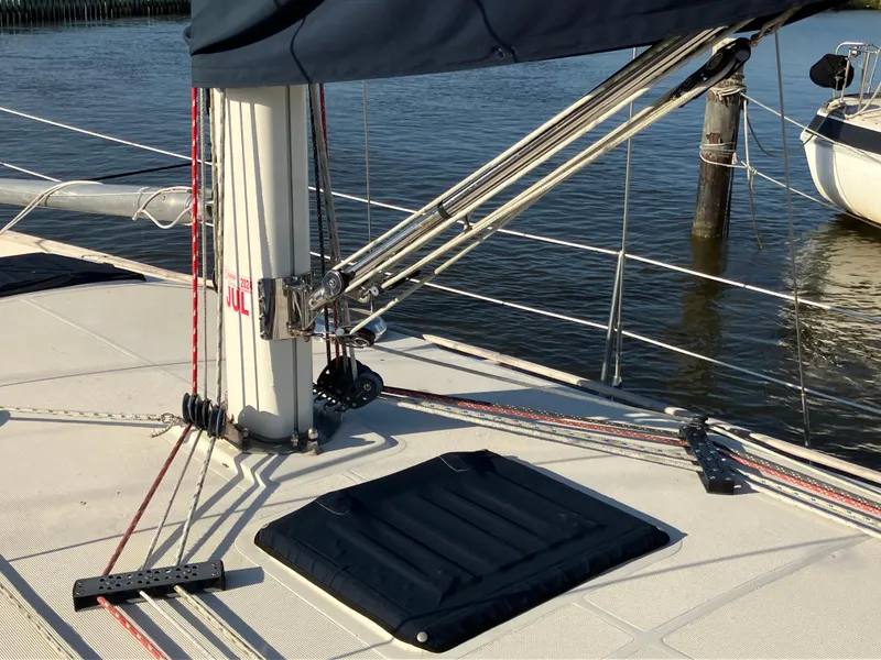 Slide: The Image of Sailboat deck with rigging and hatch, S2 11.0A, 1981 model, docked by water. - 10