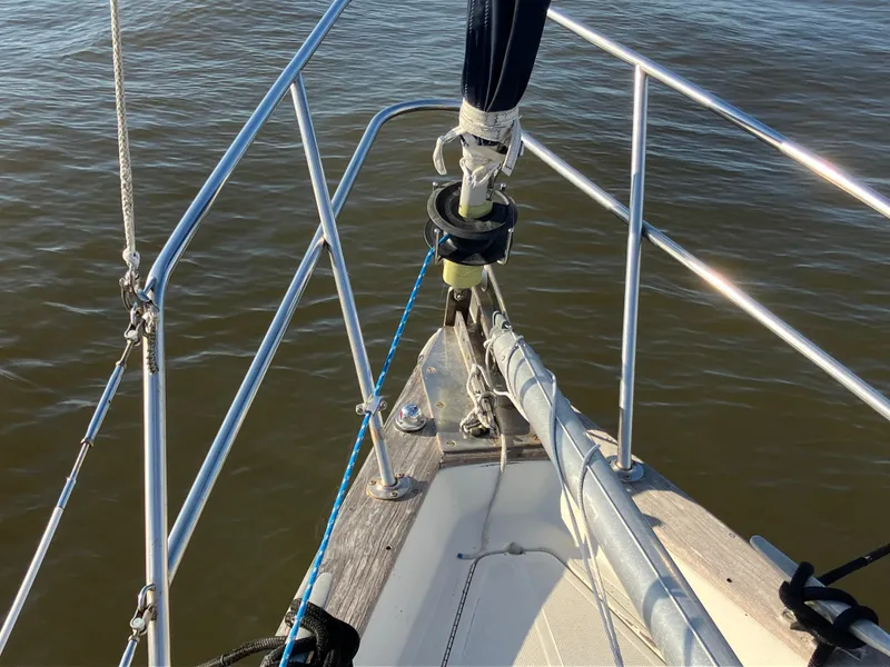 Slide: The Image of Bow of 1981 S2 11.0A sailboat with stainless steel railing on calm water. - 11