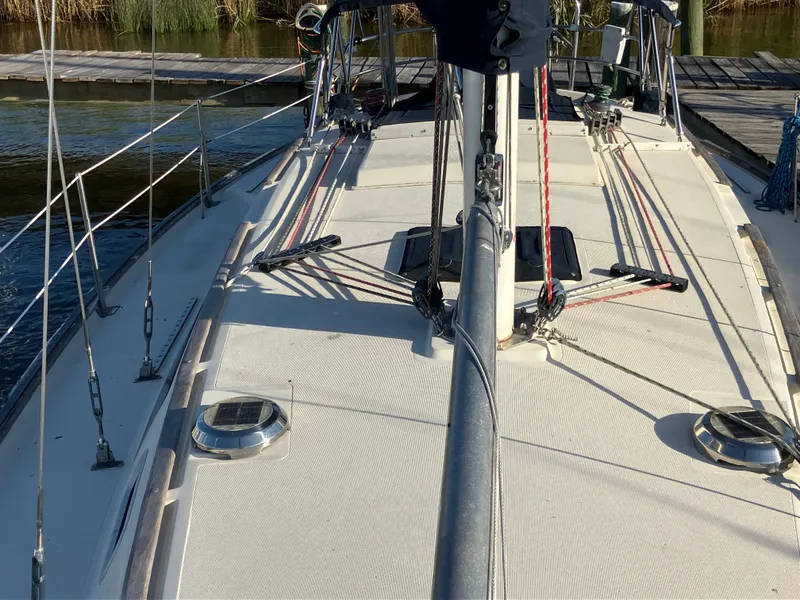 Slide: The Image of 1981 S2 11.0A sailboat deck with rigging and hatches, docked by the water. - 12