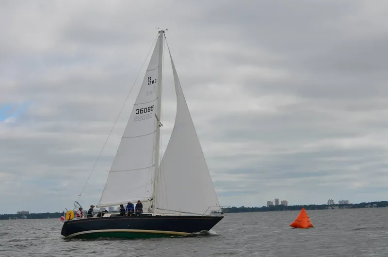 Slide: The Image of Sailboat S2 11.0A 1981 on water near orange buoy under cloudy sky. - 2