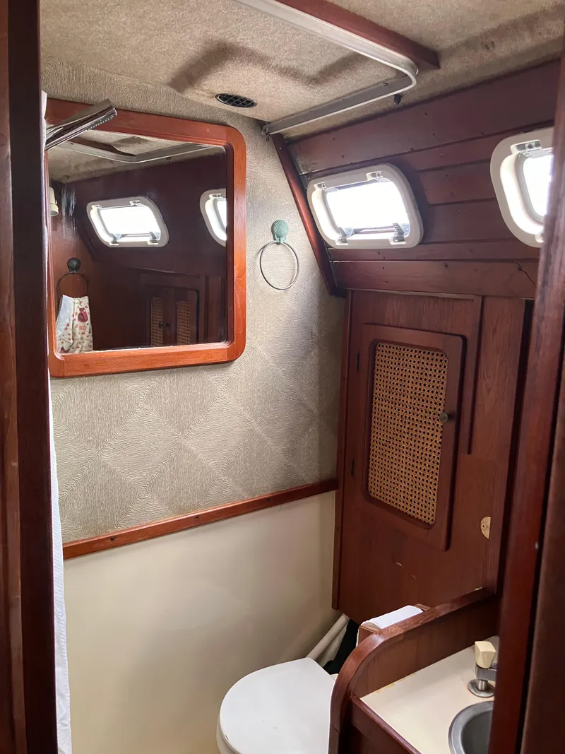 Slide: The Image of 1981 S2 11.0A yacht bathroom with wooden accents and porthole windows. - 27