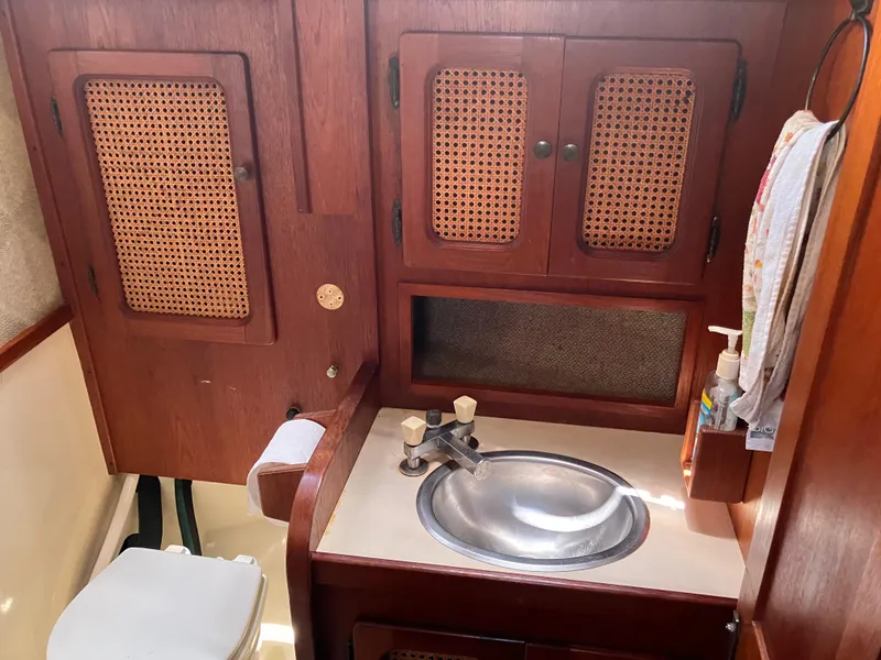 Slide: The Image of 1981 S2 11.0A yacht bathroom with wooden cabinets, sink, and toilet. - 28