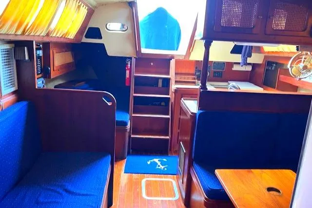 Slide: The Image of Interior of 1981 S2 11.0A sailboat with wooden furnishings and blue seating. - 36