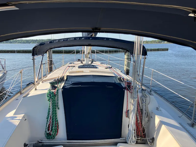 Slide: The Image of 1981 S2 11.0A sailboat cockpit with blue canopy, docked on calm water. - 6