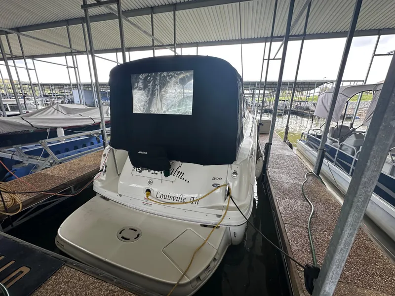 Slide: The Image of 2006 Sea Ray 300 Sundancer docked in a covered marina slip. - 2