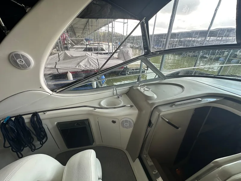 Slide: The Image of 2006 Sea Ray 300 Sundancer boat interior with helm and marina view. - 3