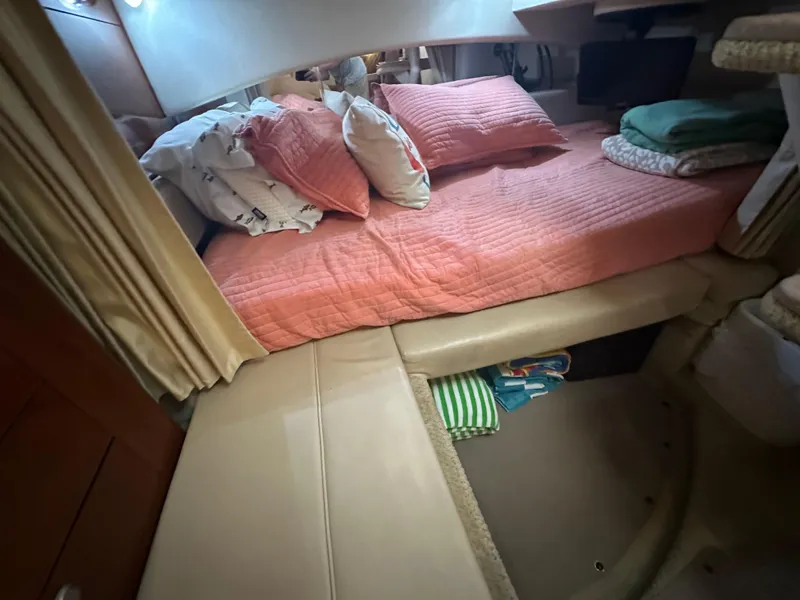 Slide: The Image of Cozy cabin interior of 2006 Sea Ray 300 Sundancer with pink bedding and storage space. - 6