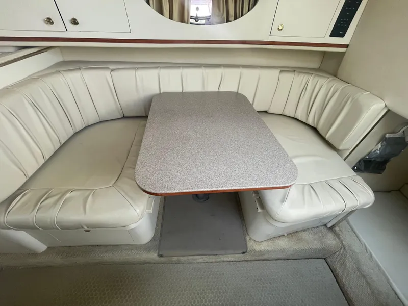 Slide: The Image of 2001 Sea Ray 290 Amberjack interior with cushioned seating and table. - 11