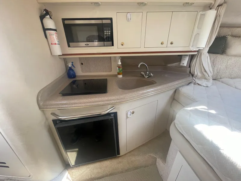 Slide: The Image of Compact kitchen area in a 2001 Sea Ray 290 Amberjack boat with microwave and sink. - 13