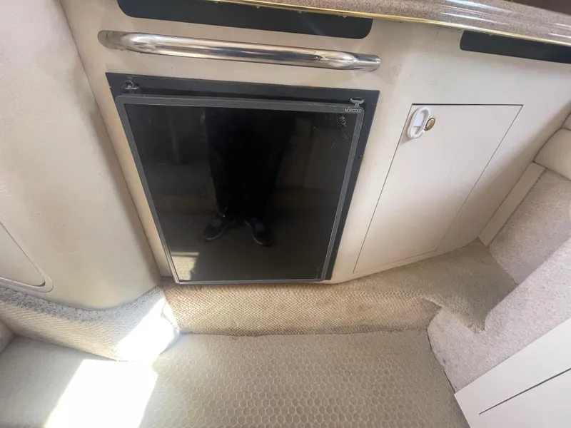 Slide: The Image of 2001 Sea Ray 290 Amberjack interior with compact fridge and storage cabinet. - 15