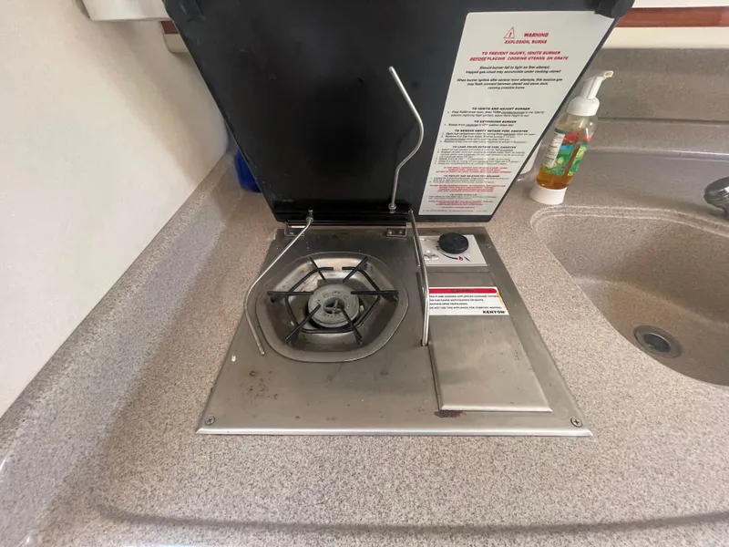 Slide: The Image of Stovetop on 2001 Sea Ray 290 Amberjack boat, featuring a single burner and safety instructions. - 16