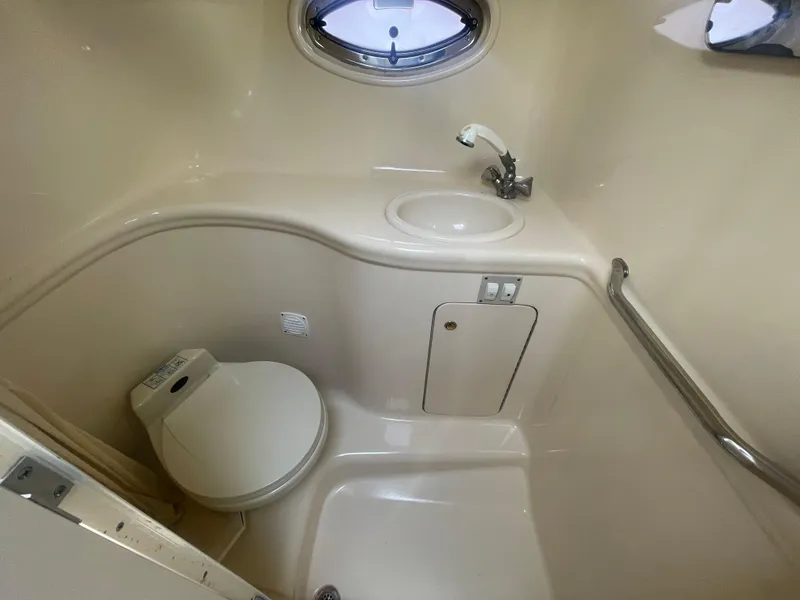 Slide: The Image of 2001 Sea Ray 290 Amberjack boat bathroom with toilet, sink, and porthole window. - 18