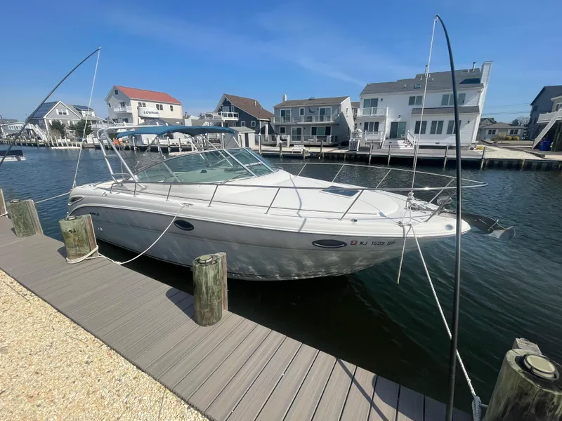 Slide: The Image of 2001 Sea Ray 290 Amberjack docked in a marina with waterfront homes. - 2