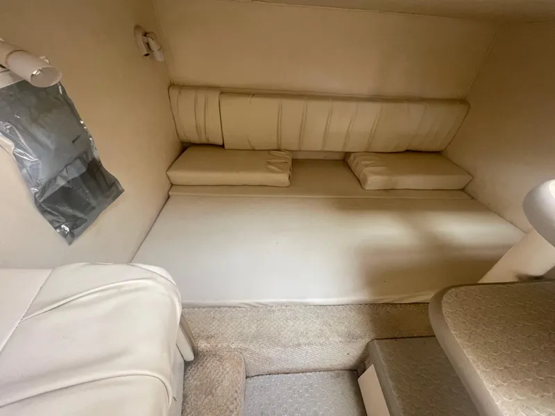 Slide: The Image of Interior cabin of 2001 Sea Ray 290 Amberjack, featuring beige upholstery and compact design. - 23