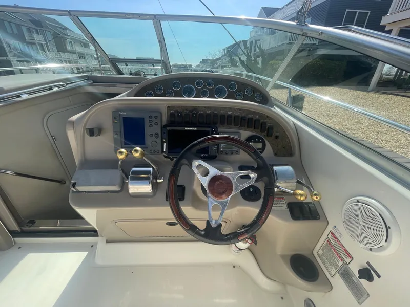 Slide: The Image of 2001 Sea Ray 290 Amberjack boat dashboard with steering wheel and navigation controls. - 25