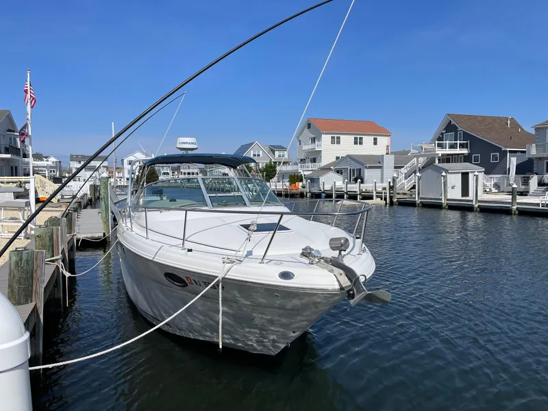 Slide: The Image of 2001 Sea Ray 290 Amberjack docked in a marina, surrounded by waterfront homes. - 3