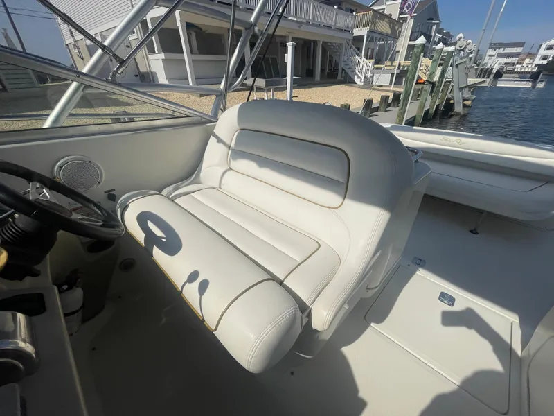 Slide: The Image of 2001 Sea Ray 290 Amberjack helm seat, white leather, dockside view. - 31