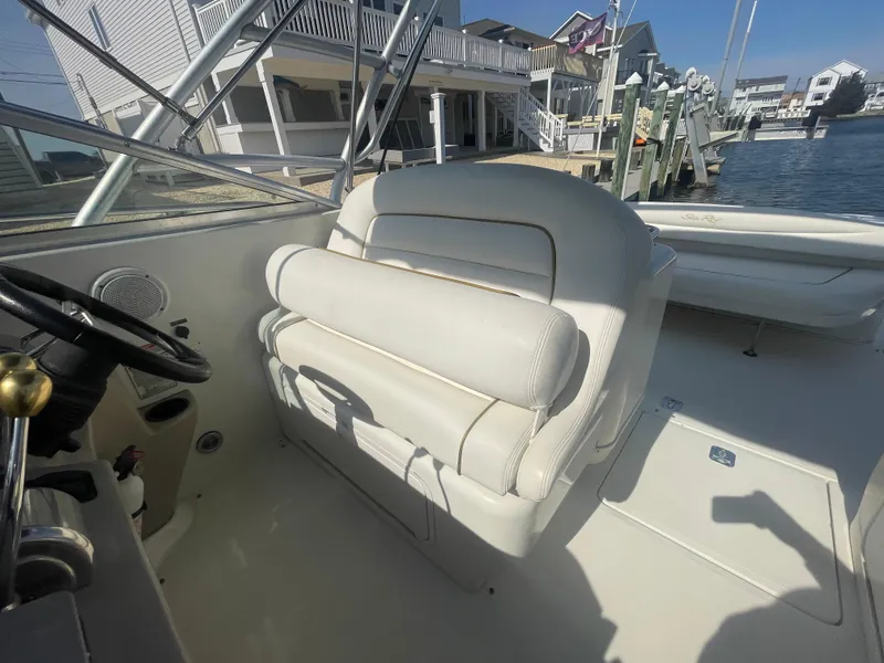 Slide: The Image of 2001 Sea Ray 290 Amberjack boat interior with white seating and steering wheel. - 32