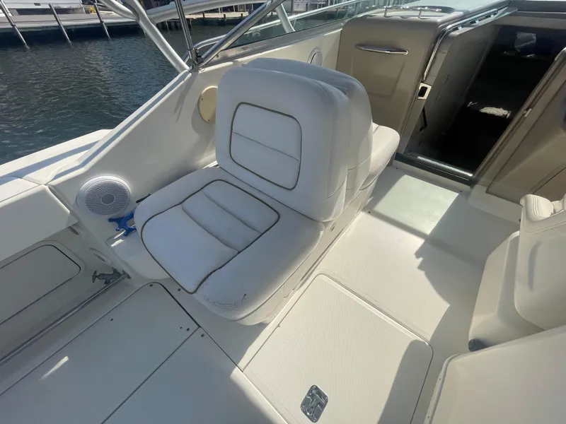 Slide: The Image of 2001 Sea Ray 290 Amberjack boat interior with white seating and speaker, dockside view. - 34