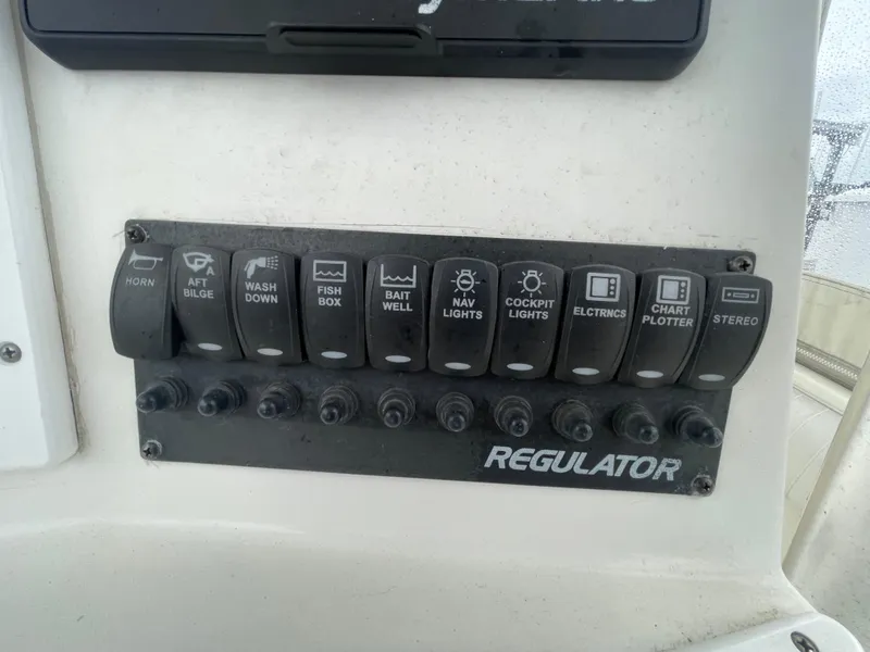 Slide: The Image of Control panel of a 2006 Regulator 24 FS boat with labeled switches. - 10