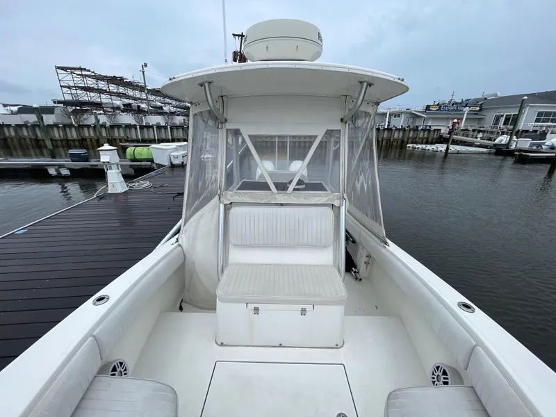 Slide: The Image of 2006 Regulator 24 FS boat docked at marina, featuring spacious seating and clear enclosure. - 11