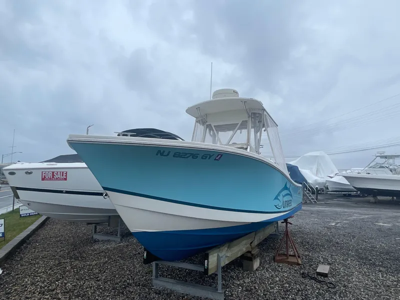 Slide: The Image of 2006 Regulator 24 FS boat on display, blue hull, overcast sky background. - 13