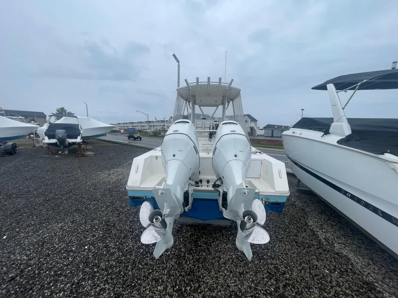 Slide: The Image of 2006 Regulator 24 FS boat with dual outboard motors, parked on gravel. - 15