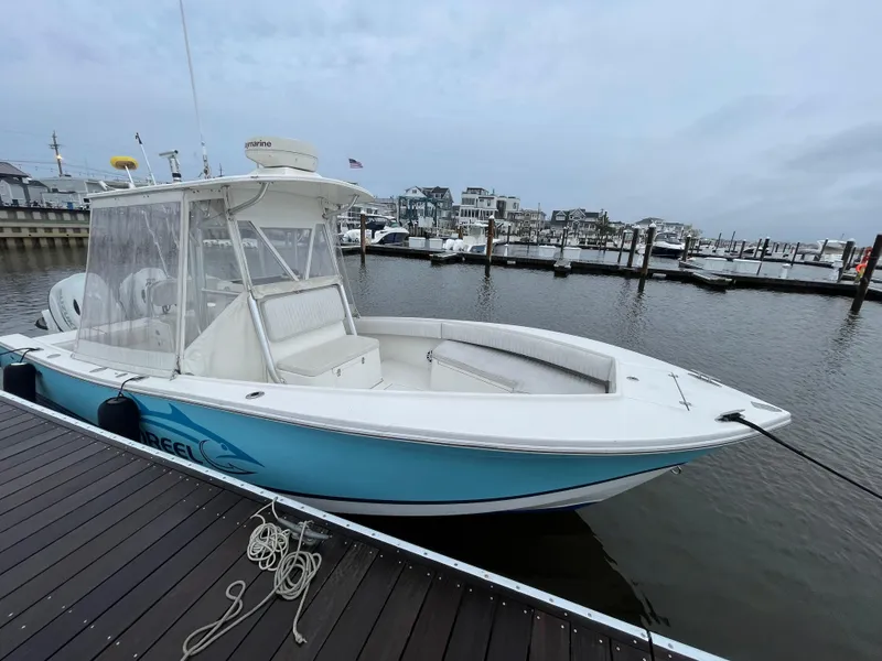 Slide: The Image of 2006 Regulator 24 FS boat docked at marina, overcast sky, calm water. - 3