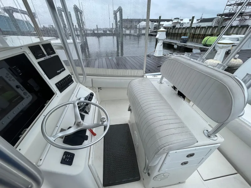 Slide: The Image of 2006 Regulator 24 FS boat interior with steering wheel and seating, docked at marina. - 7