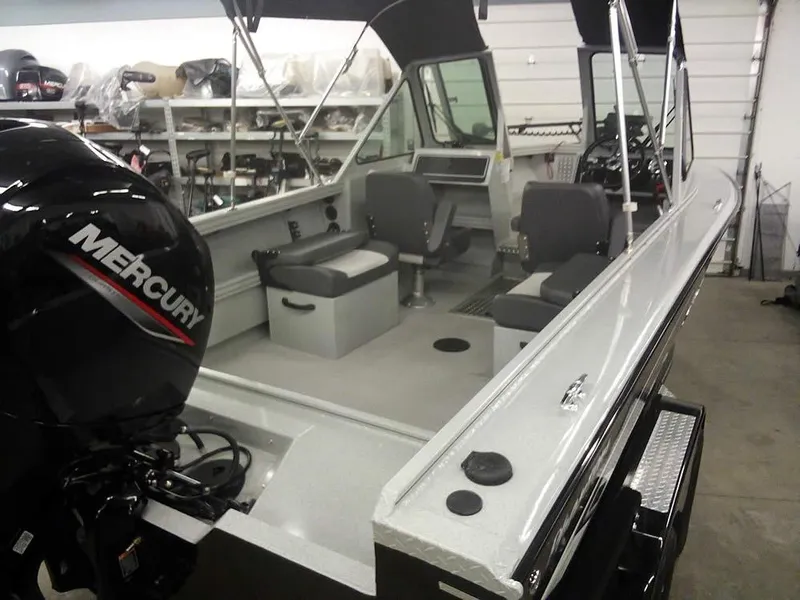 Slide: The Image of 2024 Smoker Craft Phantom 18 X2 boat with Mercury engine in a garage setting. - 28