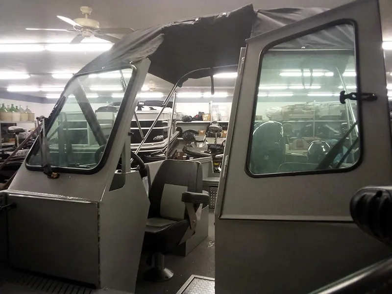 Slide: The Image of 2024 Smoker Craft Phantom 18 X2 boat interior with seating and canopy in a storage area. - 5