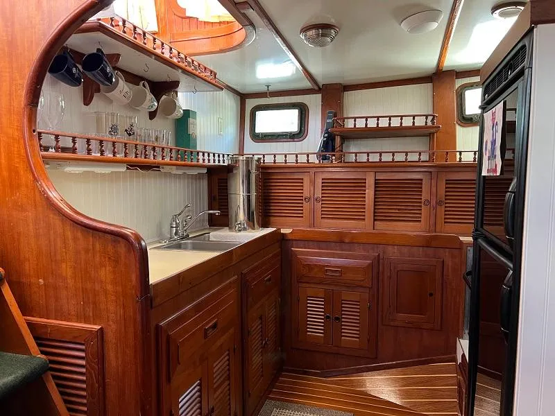 Slide: The Image of 1981 Island Trader 46 yacht kitchen with wooden cabinetry, sink, and storage shelves. - 10