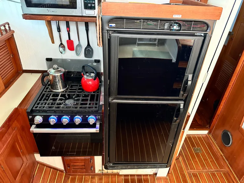 Slide: The Image of Galley kitchen in 1981 Island Trader 46 yacht with stove, fridge, and utensils. - 14