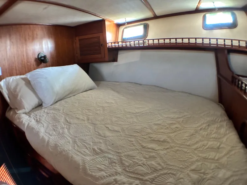 Slide: The Image of Cozy cabin interior of 1981 Island Trader 46 sailboat with bed and wooden accents. - 20