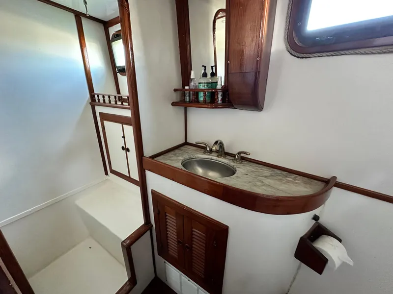 Slide: The Image of 1981 Island Trader 46 bathroom with wooden accents, sink, and storage cabinets. - 24