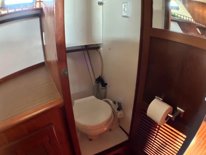 Slide: The Image of 1981 Island Trader 46 yacht bathroom with wooden accents and compact toilet. - 25