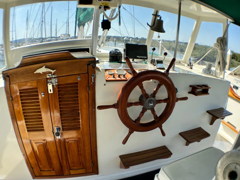 Slide: The Image of 1981 Island Trader 46 sailboat helm with wooden wheel and navigation instruments. - 5