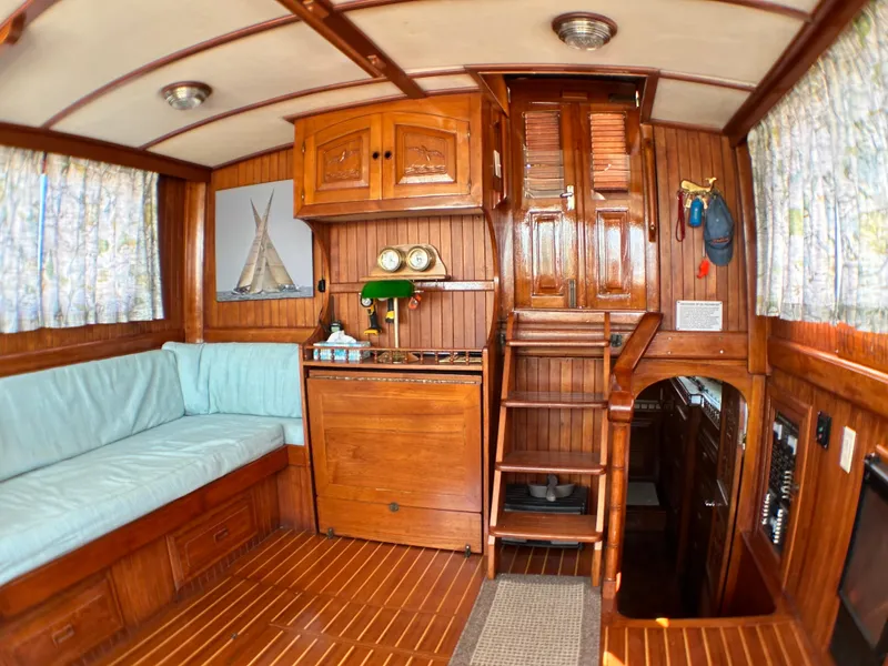 Slide: The Image of Interior of 1981 Island Trader 46 yacht with wooden paneling and cozy seating area. - 6